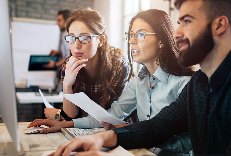 Tre persone seguono un corso sullo schermo del computer